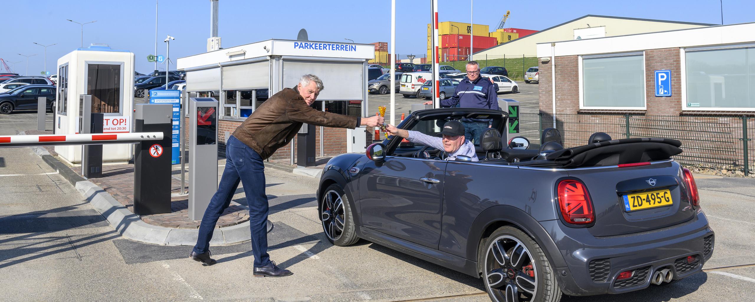 Wethouder Harry Boon deelt het eerste zakje paaseieren uit aan een bezoeker